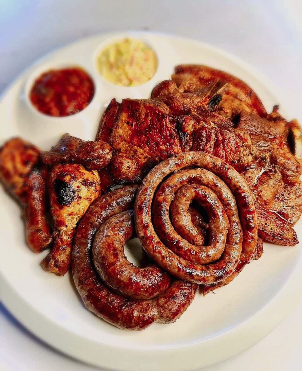 Mixed grill platter with sausage, chicken and ribs