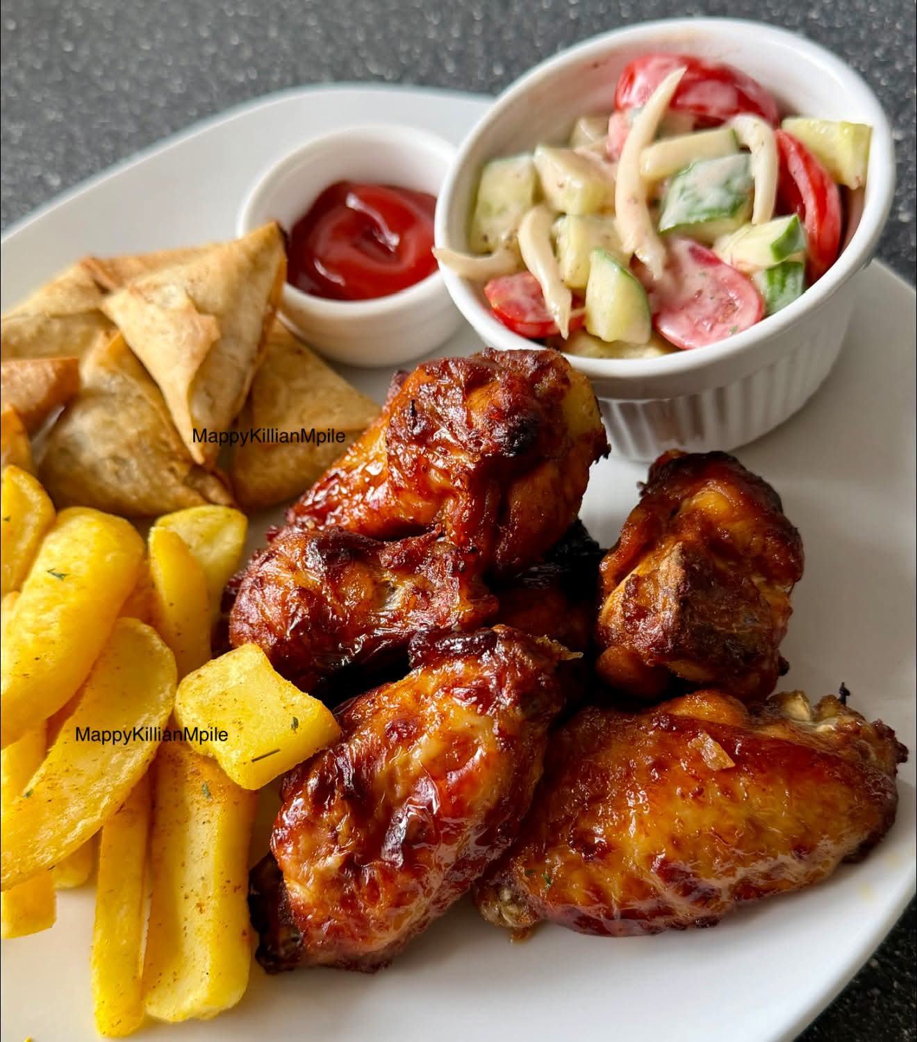Chicken wings with fries and samosas