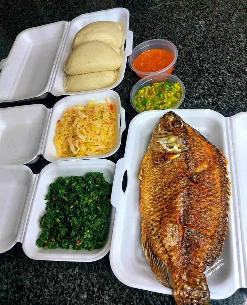 Takeaway boxes with grilled fish and nsima